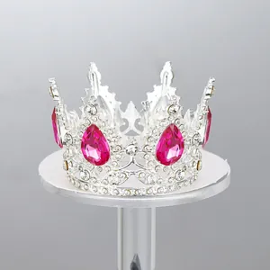 Vista detallada de una corona plateada con gemas rosas para la decoración de pasteles.
