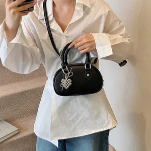 Elegante schwarze Mini-Bowlingtasche aus Leder mit Herzanhänger