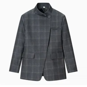 Close-up of a stylish charcoal plaid blazer with a unique stand collar and asymmetric button.