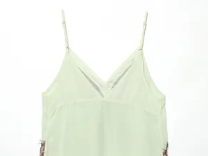 Close-up of V-neckline and delicate lace details on this light green spaghetti strap dress