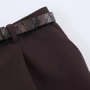 Close-up of fashionable brown trousers featuring a chic snake-print belt detail