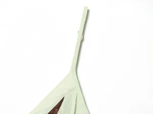 Detailed close-up of light green dress shoulder strap and lace patchwork stitching