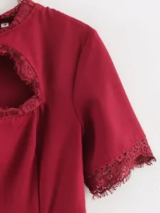 Dettaglio di un abito bordeaux con design traforato sul petto e finiture in pizzo