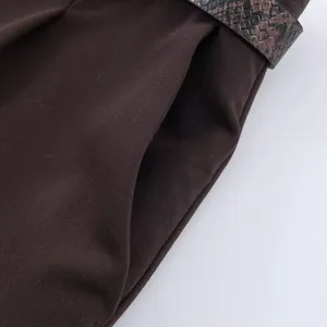 Close-up of brown casual pants with side pocket and stylish snakeskin pattern belt.