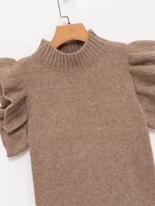 Close-up view of a brown knit vest featuring chic ruffled shoulder details and ribbed neck.