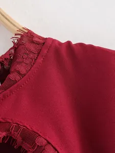 Dettaglio ravvicinato della pizzo bordeaux su un elegante mini abito a trapezio