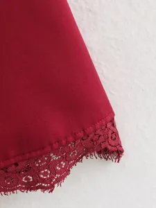 Dettaglio ravvicinato della delicata trina di pizzo rosso sull'orlo di un abito da donna