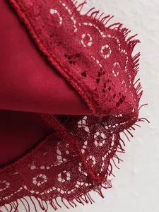 Primo piano dell'elegante bordo in pizzo bordeaux su un abito a trapezio