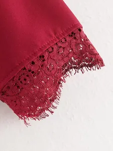 Dettaglio ravvicinato del pizzo bordeaux su un abito corto a trapezio alla moda donna
