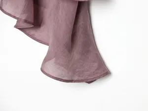 Primo piano del tessuto velato malva con cuciture dell'orlo pulite e trama a strati.
