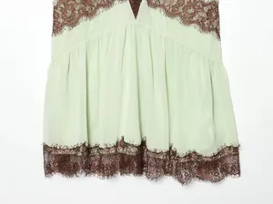 Close-up view showing the intricate brown eyelash lace trim on a mint green camisole dress.