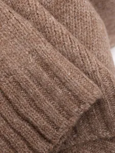 Close-up macro view showing the soft brown knitted texture and ribbed hem of the stylish vest