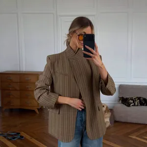Chic brown plaid blazer with stand collar and asymmetrical button closure for women