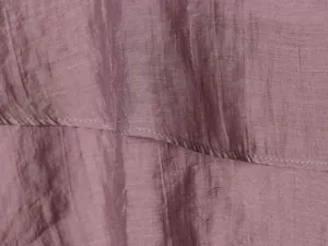 Primo piano della trama del tessuto rosa antico e dettagli delle cuciture a strati del top