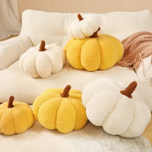 Coussins décoratifs en peluche de citrouille sherpa jaune et blanc sur un canapé confortable