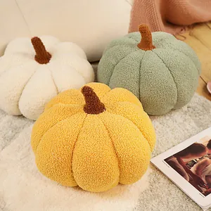 Vue détaillée de trois coussins en peluche citrouille sherpa en blanc, vert et jaune.