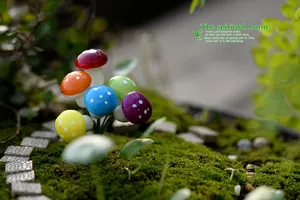 Macro detail view of colorful mini foam mushrooms in a mossy fairy garden setting