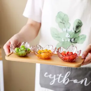 Set of handmade cherry blossom shaped glass sauce dipping bowls presented on a wooden tray
