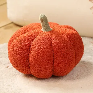 Gros plan d'un coussin en peluche citrouille orange doux avec tissu sherpa texturé