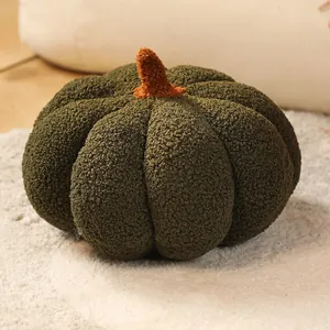 Gros plan d'un coussin en peluche citrouille vert foncé sur un tapis blanc doux et duveteux