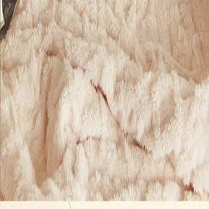 Détail macro d'une couverture en polaire corail crème avec une texture épaisse et douce