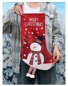 Person holding a red Christmas stocking with a cute snowman and Merry Christmas text.