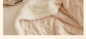 Gros plan montrant les textures douces de polaire Sherpa et de velours gaufré de la couverture.