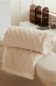 Gros plan d'une couverture en fausse fourrure beige avec motif à losanges et texture