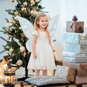 Detail view of iridescent butterfly fairy wings worn by a girl near a Christmas tree