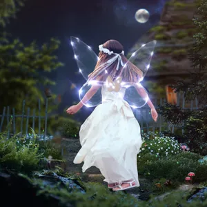 Back view of a young girl wearing magical glowing LED fairy wings in a dark forest scene