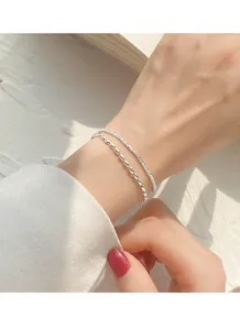 Close-up of 925 silver-plated double-layer bracelet with rice grain and sparkling chains.