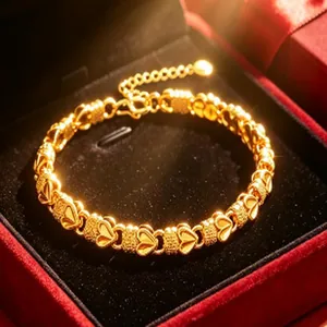 Vue détaillée d'un élégant bracelet doré à maillons cœur dans un écrin en velours rouge