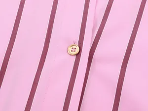 Detailed macro view of pink and maroon striped shirt fabric with a gold button accent