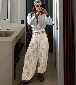 Detail view of fashionable white lace wide-leg pants with elastic waist for women