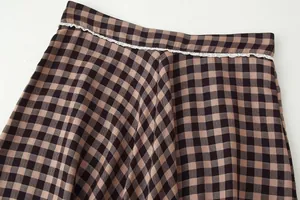 Detailed close-up showing the checkered pattern and white lace trim on the skirt waist