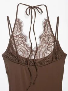 Detail shot of the intricate floral lace patchwork on a brown halter-neck bodysuit.