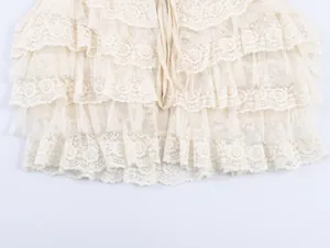 Détail rapproché de volants en dentelle florale crème élégante sur un haut à couches