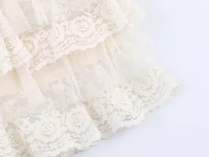 Gros plan détaillé de dentelle florale crème superposée sur un haut de mode vintage