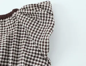 Detalle de tela de cuadros vichy marrones con un diseño de lazo con volantes grandes
