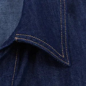 Close-up detail of dark blue denim shirt collar with contrast stitching