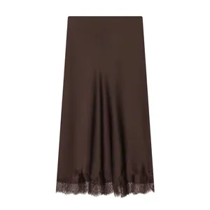 Detail view of the elegant brown satin midi skirt with delicate lace trim at the hem.