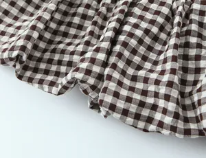 Primer plano de la textura de la tela de cuadros marrones con detalle de dobladillo fruncido