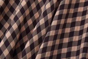 Close-up detail of brown and black gingham fabric showing high-quality twill texture