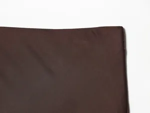 Macro detail showing the rich texture and smooth finish of the brown satin midi skirt fabric