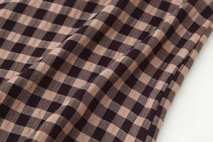Macro detail of classic brown and black checkered fabric texture for chic women's skirt