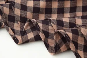 Detailed macro shot of brown and black gingham fabric texture showing fine stitching