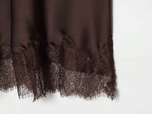 Close-up detail showing the intricate brown lace hem on a high-quality satin midi skirt