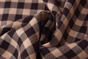 Macro view of high-quality brown and black plaid fabric texture with twill weave detail