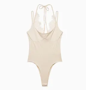 Detailed view of elegant beige halter neck bodysuit with delicate white lace trim