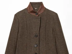 Close-up of a vintage brown houndstooth blazer with stand-up collar and black buttons